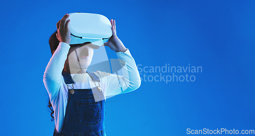 Image of Future, virtual reality or girl with glasses, metaverse or augmented reality on a blue studio background. Futuristic, kid or child development with vr headset, online gaming or digital transformation