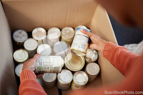 Image of Donation, food in cans in box and hands of man checking stock, decision and volunteer with ngo help. Support with charity, choice and refugee at grocery distribution for sustainable community service