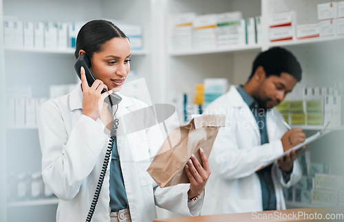 Image of Pharmacist, telephone and medicine package for customer service, healthcare communication and inventory support. Medical worker, people or doctor on phone call with pharmacy product or paper bag