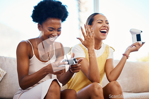 Image of Women on sofa playing video game, laughing and relax in home living room together on internet with controller. Online gaming, esports and happy gamer girl friends on couch on virtual app in apartment