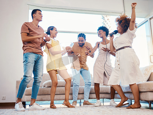 Image of Karaoke, party and friends dancing in the living room with a microphone to music, playlist or radio. Happy, diversity and young people singing, moving and having fun together for bonding at home.