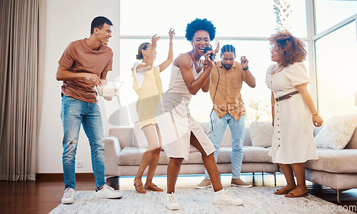 Image of Singing, music and friends doing karaoke in the living room with microphone to playlist or radio. Happy, diversity and young people dancing, bonding and having fun together for entertainment at home.