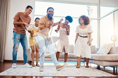 Image of Energy, entertainment and friends singing karaoke in the living room with a microphone to music, playlist or radio. Happy, diversity and young people dancing, bonding and having fun together at home.