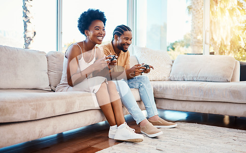 Image of Gamer, funny and a black couple on a sofa in the living room of their home together for bonding. Love, fun or leisure with a gaming man and woman playing online using a console in their house