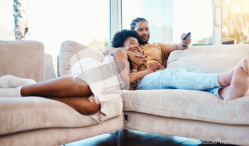 Image of Couple, watching tv and relax on home sofa together with love, care and happiness. African man and woman in a living room with a remote control for streaming movies, show or series on a couch