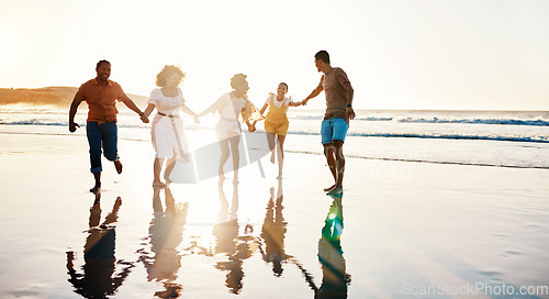 Image of Friends, running and people happy at sunset beach for fun, freedom and travel with care. Diversity, men and women group holding hands in nature with sand, love and happiness on a vacation or holiday