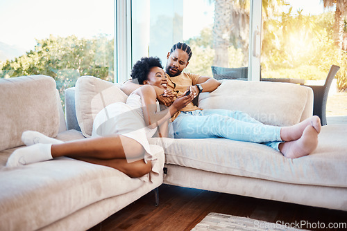 Image of Happy, relax and a black couple on the sofa, watching tv and talking in a house. Smile, love and an African man and woman with care, speaking and conversation on the living room couch for a movie