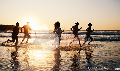 Image of Sunrise, beach and friends with freedom, running and having fun in water together on summer vacation. Ocean, silhouette and group of people at the sea for holiday, bond and travel celebration in Bali