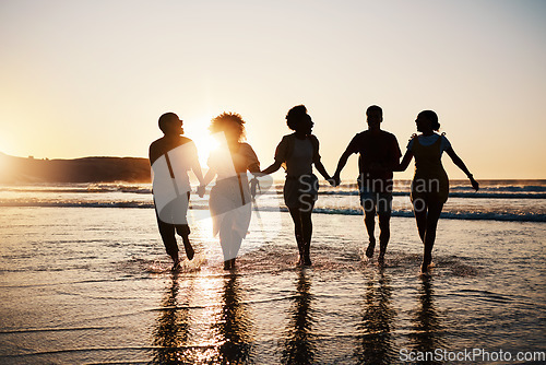 Image of Holding hands, silhouette and friends at the beach with freedom, fun and bonding at sunset. Ocean, shadow and group of people at the sea for travel, adventure and journey in sea trip in Los Angeles