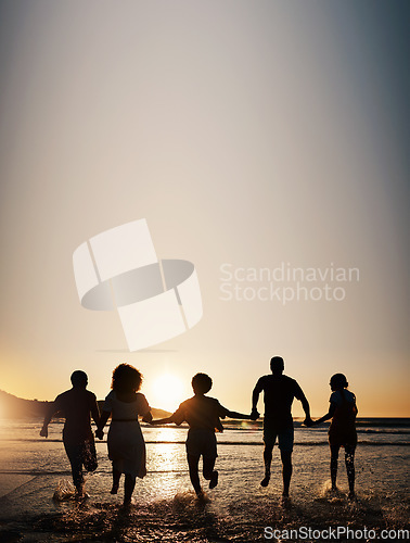 Image of Sunset, water splash and friends holding hands at a beach with freedom, running or fun on summer vacation. Ocean, silhouette and people shadow in solidarity at the sea for travel, bond or celebration