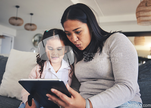 Image of Tablet, study and a mother on the sofa with her daughter in the living room of their home together. Education, family or children with a mother and girl looking at online homework for learning