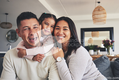 Image of Hug, smile and portrait of girl with her parents bonding together in the living room of their home. Care, love and child holding her father and mother while relaxing in the lounge of a family house.