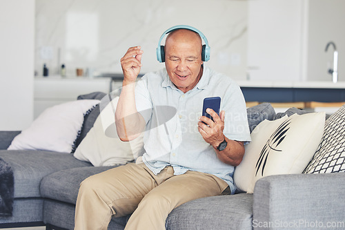 Image of Headphones, phone and old man in living room dancing on sofa, listening to streaming radio and relax. Music, fun and excited senior person on couch with cellphone, earphones and online in retirement.