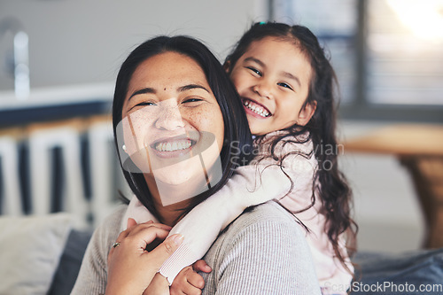 Image of Hug, mother and daughter smile for a portrait at home with love, care and happiness. A young woman and girl child together on a lounge sofa for fun time, playing and security or relax in family house