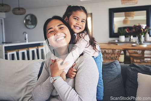 Image of Hug, smile and portrait of mother and daughter on sofa for love, care and support. Happy, calm and relax with woman and young girl embrace in living room of family home for peace, cute and bonding