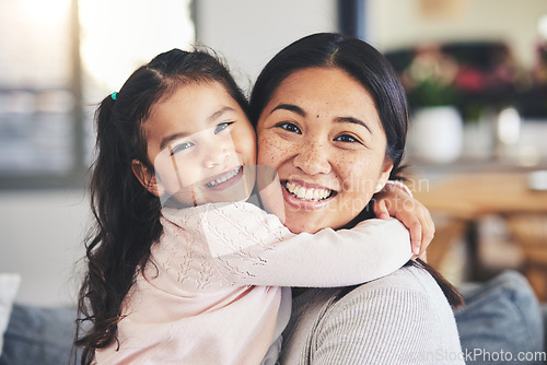 Image of Smile, mother and daughter hug for a portrait at home with love, care and happiness. A young woman and girl child together on a lounge sofa for fun time, playing and security or relax in family house