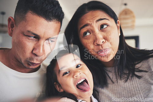 Image of Selfie, silly and portrait of girl with her parents bonding in the living room of their home. Goofy, happy and child taking a picture with her mother and father with funny faces at their family house