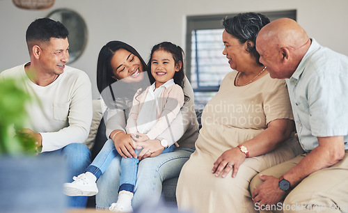 Image of Happy, care and a big family on the sofa with a child during a visit for love, bonding and playing. Smile, laughing and a girl kid with parents and grandparents on the home couch to relax and talk