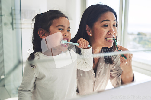 Image of Mother, child and brushing teeth in dental cleaning hygiene, morning routine or healthcare together by mirror in bathroom. Happy mom and daughter mouth in tooth whitening, oral or gum care at home