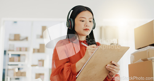 Image of Business, fashion designer and Asian woman with checklist for planning, logistics and order delivery. Retail, commerce and girl listen to music for productivity for clothes, shipping and distribution