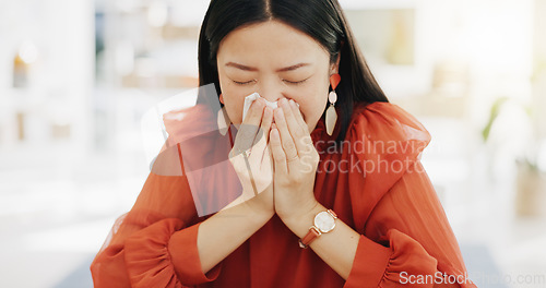 Image of Tissue, blowing nose and sick Asian woman in office with sinus infection, virus and allergy symptoms. Business, corporate workplace and female worker at desk with cold, fever problem and flu sickness