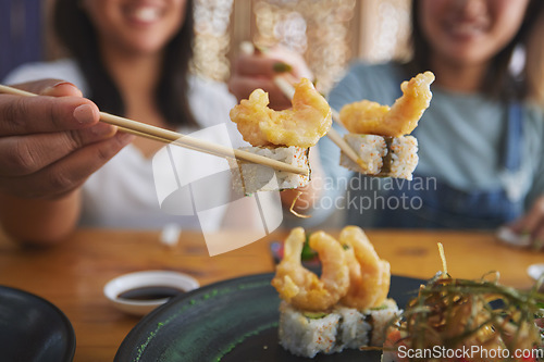 Image of Chopsticks, woman hands and shrimp sushi closeup at a table with Japanese cuisine food at restaurant. Young women, eating and tempura prawn with fish for lunch and meal on a plate with a smile