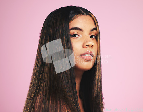 Image of Portrait, salon and hair with a woman on a pink background in studio for shampoo treatment. Face, skincare or haircare and a confident young model with natural beauty or aesthetic keratin cosmetics