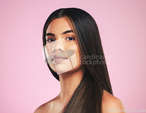 Image of Portrait, beauty and hair with a woman on a pink background in studio for shampoo treatment. Face, skincare or haircare with a confident young model at the salon for natural or keratin cosmetics