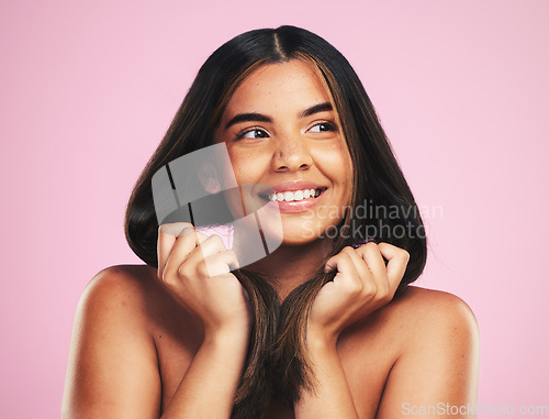 Image of Beauty, hair and happy woman in studio for cosmetic, shampoo and results, treatment or satisfaction on pink background. Haircare, smile and female model with strand strength, growth or smooth texture