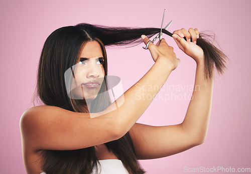 Image of Hair cut, scissors and frustrated woman with beauty tool and DIY treatment in a studio. Growth issue, annoyed and Brazilian hairstyle with female model from Brazil with equipment and pink background