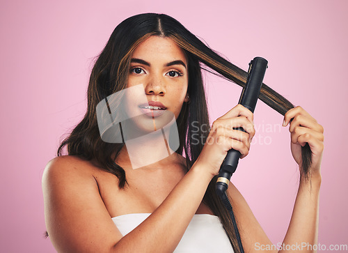 Image of Portrait, woman and hair care with iron for studio beauty, cosmetic treatment or shine on pink background. Face of model, hairstyle or heating equipment of electric tools for smooth aesthetic texture