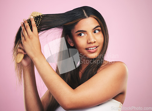 Image of Woman, hair and care with brush in studio for healthy texture, shine and keratin on pink background. Natural beauty, face and model with comb tools for clean aesthetic hairstyle with growth shampoo