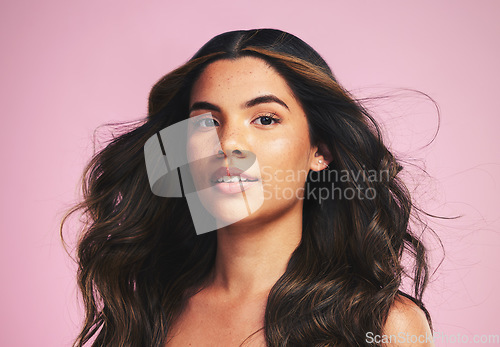 Image of Portrait, hair care and woman with beauty, wind and texture on a pink studio background. Face, person or model with skincare, cosmetics or dermatology with self care, volume and aesthetic with growth