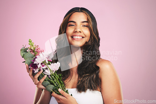 Image of Happy woman, flowers and portrait in studio for skincare, natural cosmetics and aesthetic shine on pink background. Model smile for eco beauty with floral plants, sustainable dermatology and bouquet