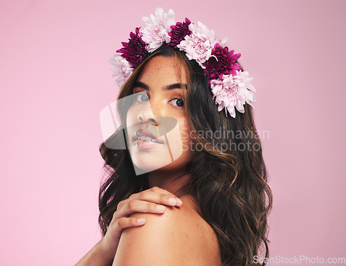 Image of Woman, flower crown and portrait in studio for beauty, natural skincare and spring plants on pink background. Face, model and floral wreath for sustainability, eco dermatology and hair care cosmetics