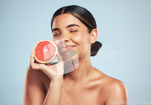 Image of Skincare, smile and woman in studio with grapefruit for natural skin beauty or wellness on grey background. Happy, fruit and female model with citrus cosmetics for vitamin c, collagen and anti aging