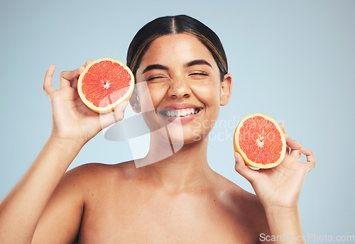 Image of Happy, woman and grapefruit skincare in studio for natural, cosmetic and wellness on grey background. Face, smile and model with citrus, fruit and organic treatment for anti aging, glow or vitamin c