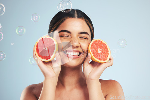 Image of Smile, woman and grapefruit skincare in studio for natural, cosmetic or wellness on grey background. Beauty, happy and model face with citrus facial, fruit or vitamin c, collagen and bubble aesthetic