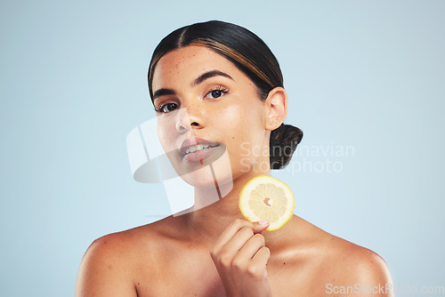 Image of Portrait, woman and lemon in studio for skincare, wellness and organic cosmetics on grey background. Fruit, slice and face of model with citrus treatment for vitamin c, collagen and anti aging detox