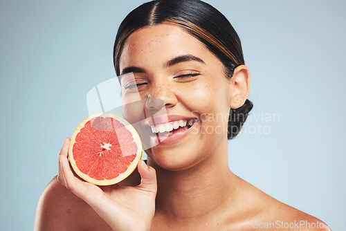 Image of Happy, skincare and woman in studio with grapefruit for natural skin beauty or wellness on grey background. Smile, fruit and female model with citrus cosmetics for vitamin c, collagen and anti aging