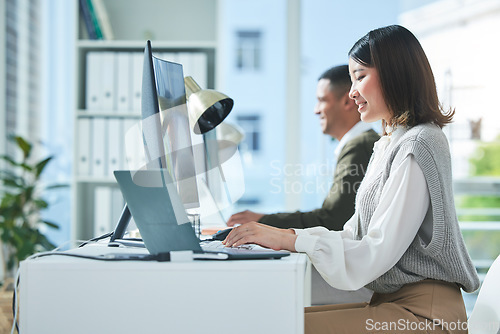 Image of Business, planning and asian woman on laptop and computer in office for research or strategy in coworking space. Online, search and happy female designer smile for creative, networking or design