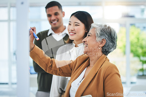 Image of Senior woman, writing and manager at glass board with creative team and sticky notes agenda. Calendar planning, content creator schedule and management staff laughing in a business meeting teamwork