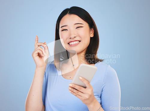 Image of Woman, phone and idea, decision and portrait for university, college or education on blue background. Young asian person or student with solution or thinking on mobile for learning or chat in studio