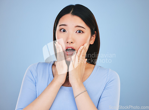 Image of Scared, portrait and Asian woman with fear from news, announcement or horror story on blue background in studio. Shock, face and person with wow, emoji or facial expression with stress or anxiety