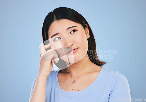 Image of Decision, thinking and Asian woman with ideas, choice and problem solving on a blue studio background. Solution, Japanese person or model brainstorming, doubt and mockup space with questions or emoji