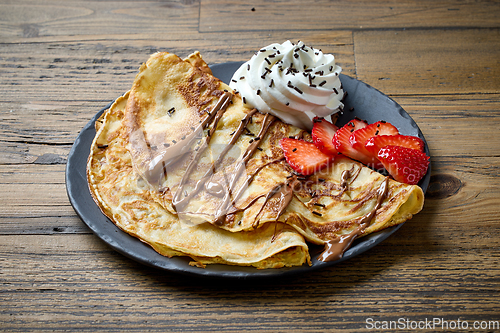 Image of plate of crepes on wooden table