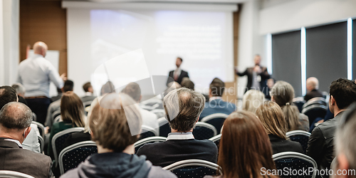 Image of I have a question. Group of business people sitting in conference hall. Businessman raising his arm. Conference and Presentation. Business and Entrepreneurship