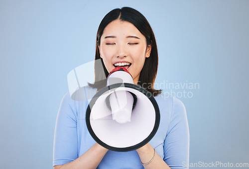 Image of Woman, megaphone and voice for news, broadcast or student sale and announcement on blue background. Young asian person with noise for call to action, university attention or college speaker in studio