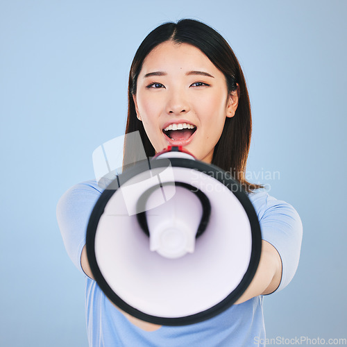 Image of Woman, megaphone and voice for announcement, broadcast or student news and sale on blue background. Young asian person in portrait for call to action, university attention or college speech in studio