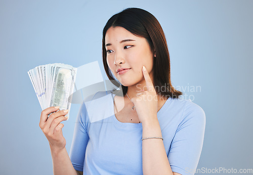 Image of Woman, money and winner thinking of bonus offer, financial success and winning, finance loan or choice. Asian person or customer for cash, savings decision or profit ideas on blue, studio background